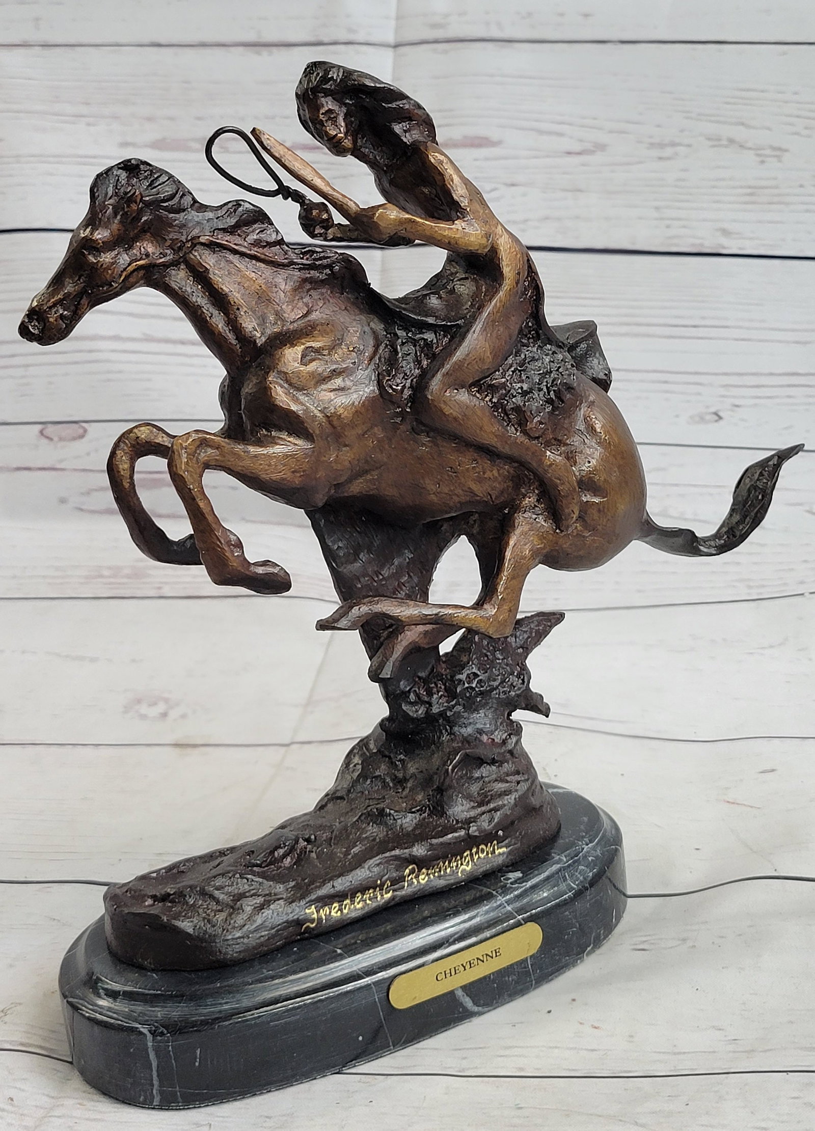 Warrior Riding Horse Bronze Sculpture: A native American Indian gallops across the desert with his horse. Armed with a spear, he leans into his horse body, ready to attack. The horse keeps his head low, its nose pointed forward as he runs 
