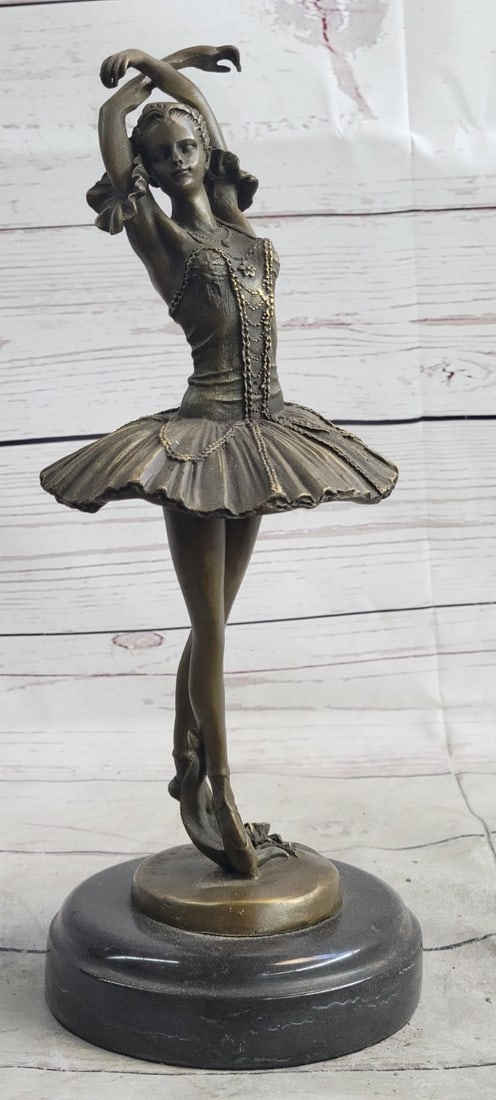 Lady Ballerina Bronze Sculpture: The ballerina stands tall and elegant as she looks to the heights of the balcony lovingly admiring the audience. She wears a tiara and a modern tutu, the classic costume of the ballet dance, which has