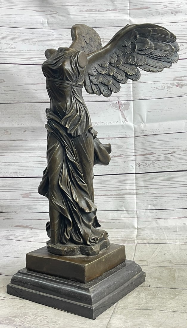 Winged Nike Bronze Statue: This bronze sculpture was cast using the lost-wax method and stained with a brown patina finish and stands upon a marble base. Dimensions: Height 19 X Width 10 inches. Weight: 21 LBS.