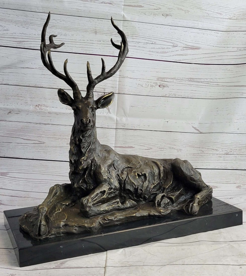 Animal Edition Bronze Statue: The majestic male deer can be imagined resting on the forest floor under the rushing of the wind through the rustling leaves of the tree canopy. In a regal manner, he stares out enigmatically at the b