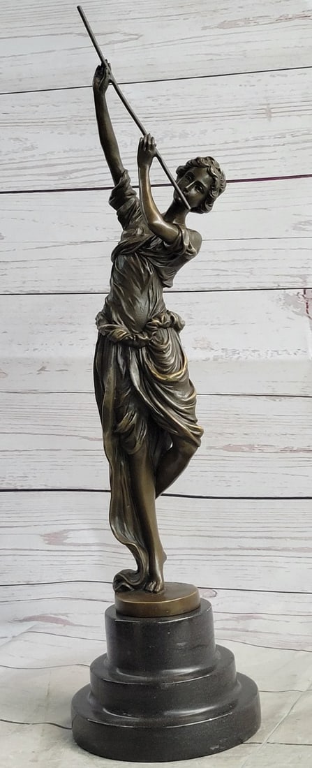 Girl Playing Flute Bronze Sculpture: As she dances, she plays her flute ever so graciously as if it is the music from the heavens. She is a gorgeous and quaint girl, she wears a loose flowing dress that bunches by her legs and flows with