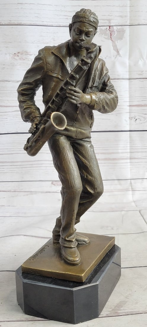 Saxophone Player Musician Bronze Sculpture: This musician blares out notes as he plays his Saxophone high in the air. He lifts his arms and bends his elbows letting his Saxophone and body move as one. He wears a fitted suit jacket and a tie.