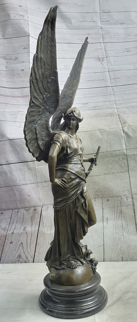 Winged Victory Louvre Nike Bronze Sculpture: The divine angel's presence demands a hallow glow around her as she valiantly stares off into the cosmos with open wings. She holds the handle of her belted sword used in the heavenly defense in the w