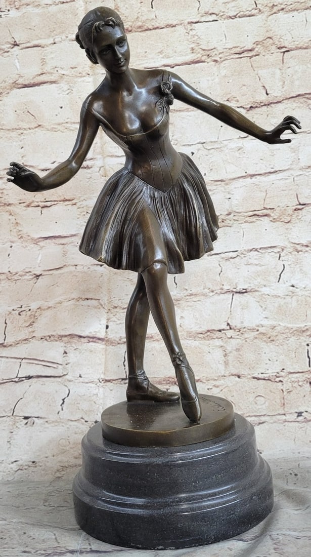 Ballerina Bronze Sculpture: The skirt is wide and flowing at the hips giving nice dimension to the dancer. On her feet, she wears ballet slippers that crisscross around her ankles and tie. Her hair is tied back split into