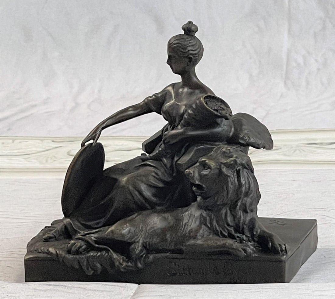 Opulent of Royal Woman Bronze Statue: The noble maiden sits in a chair holding a shield and a cornucopia in the other arm. She stares out as though posing for a portrait with a majestic lion at her feet giving a combined regal air. The