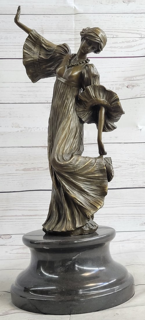 Danseuse Bronze Sculpture: This beautiful sculpture of a woman standing with her left leg raised up as she looks downward. She is wearing this long very elegant and Conservative dress that covers her head to toes. It has these
