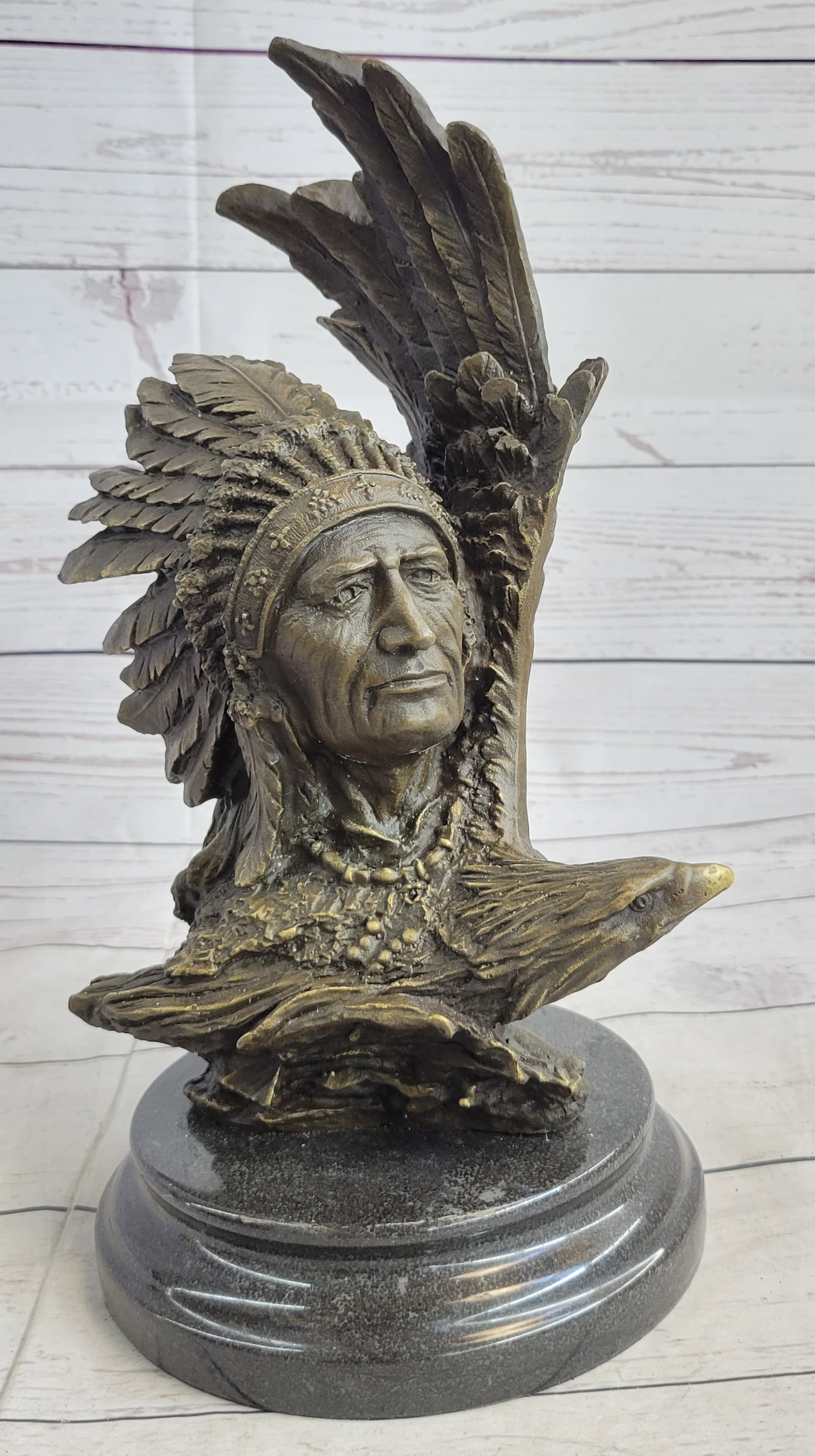 Native American With Eagle Bronze Statue: The Native American shaman, or medicine man, stands to look at something lost in the faraway horizon, bracing his head against an eagle that soars with open wings. The eagle is a sacred messenger. Eag