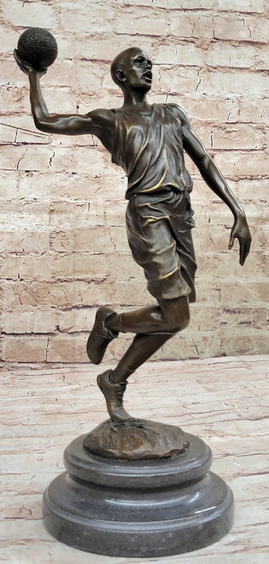 Michael Jordn Tribute Bronze Sculpture: He is a legend on the court. This basketball player tumbles down the court. As he nears the 3-point line, he holds the ball in his large palm and prepares to shoot. He begins to leap towards the net.