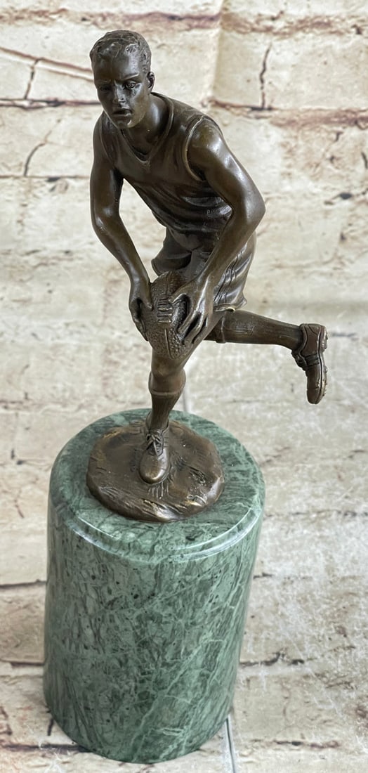 Rugby Player Trophy Bronze Statue: A muscular football player runs for the end field, trying to skip the yards and avoid being tackled. His powerful legs ache as he sprints and dodges. He holds the ball under him protectively. Every on