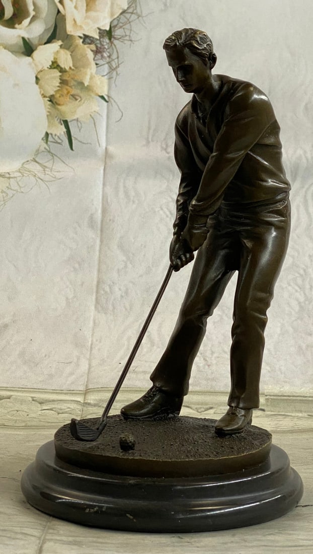 Golfer Bronze Statue: A golfer tilts his head up to the sun and watches his ball rise. He holds his form and stance, tracking the position of the ball and how close to the green it may land. His body twists with his