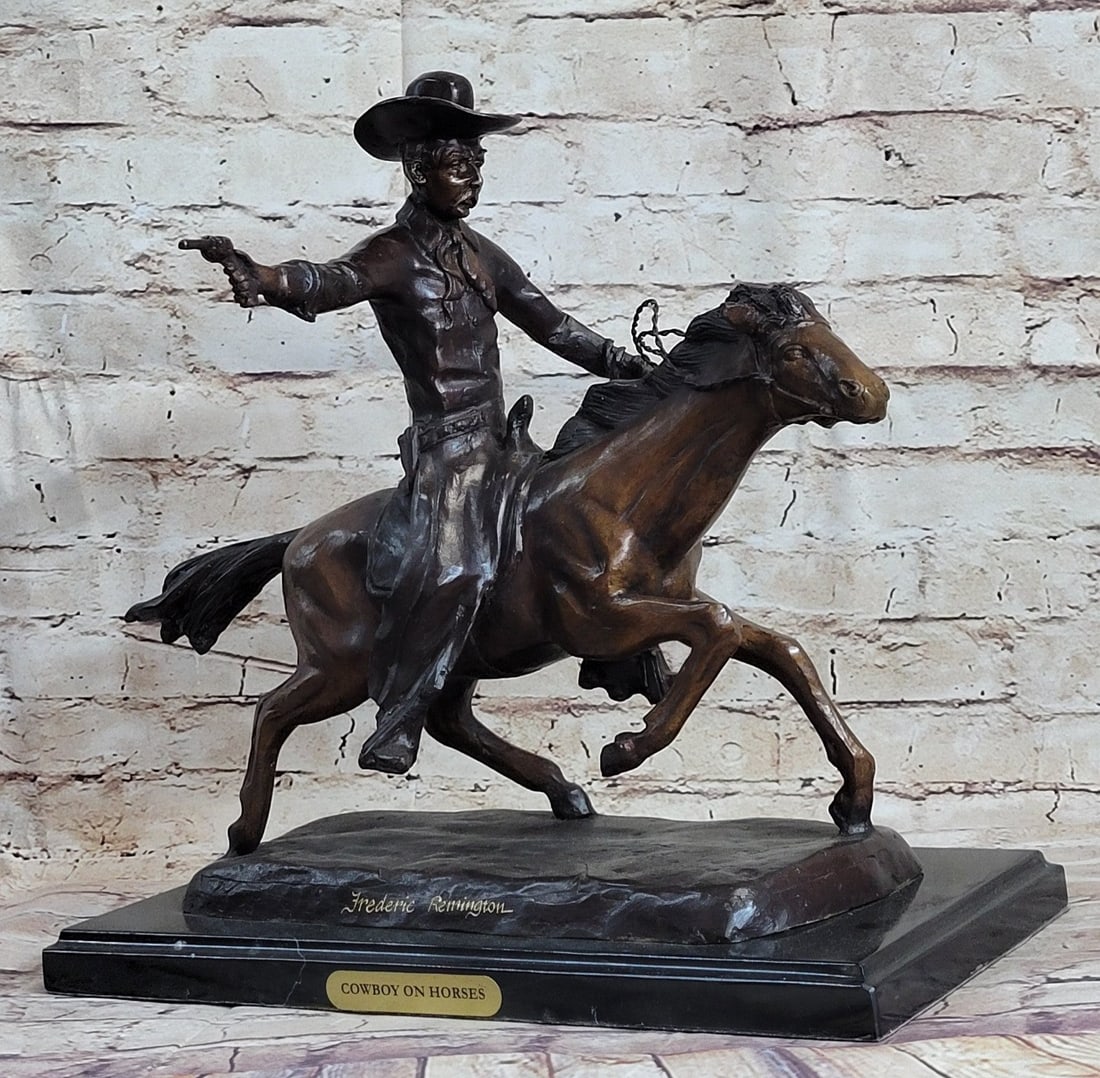 Cowboy Charges Bronze Sculpture: A cowboy charges across the dry land with his gun in the air. His horse gallops, with its nose, pointed forward. The cowboy holds the reins tightly in his free hand and he squeezes his thighs on each 