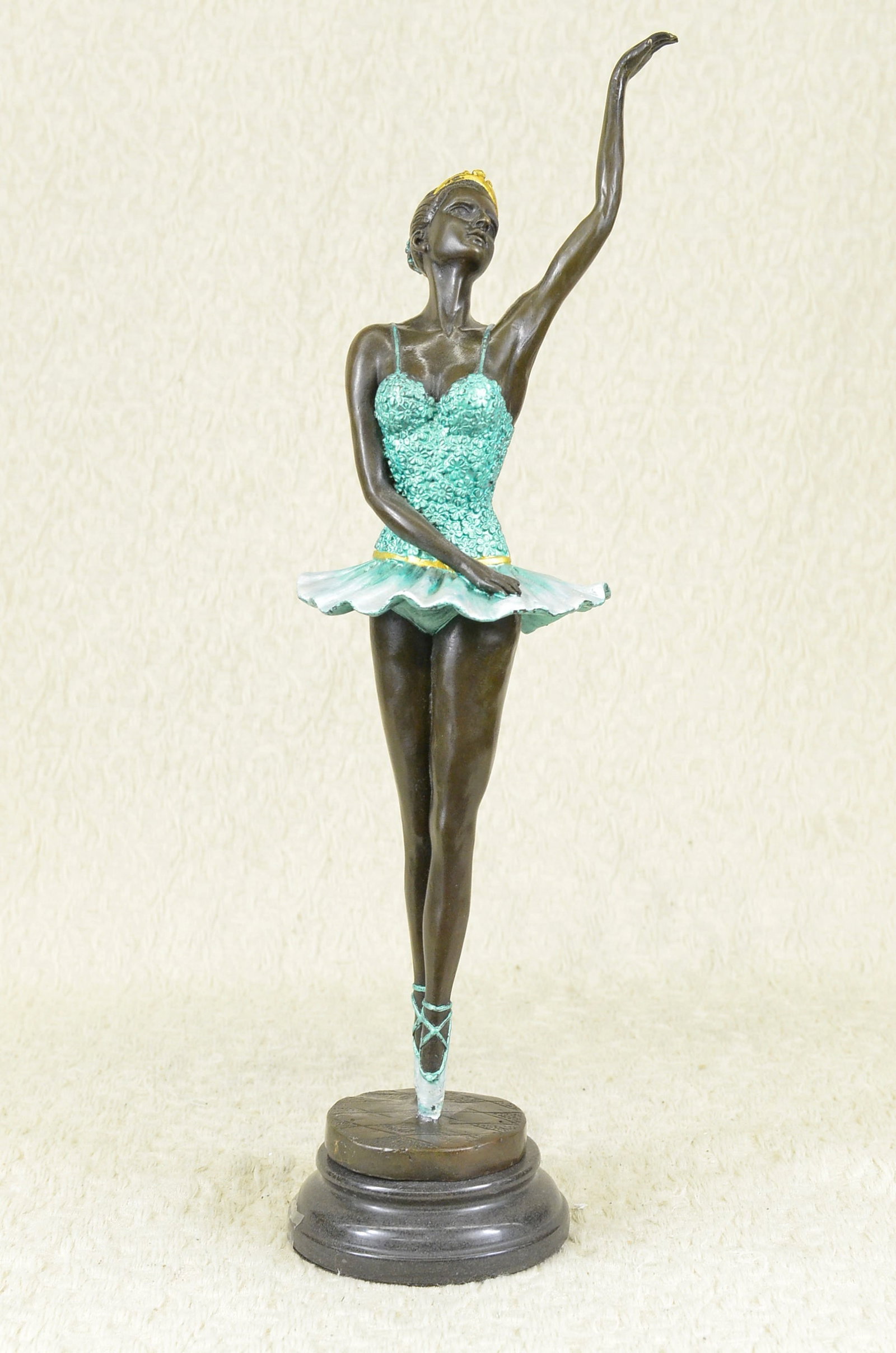 Well Trained Ballerina Bronze Statue: The ballerina stands tall and elegant as she looks to the heights of the balcony lovingly waving to the admiring audience in a standing ovation. She wears a tiara and a tutu, the classic costume of