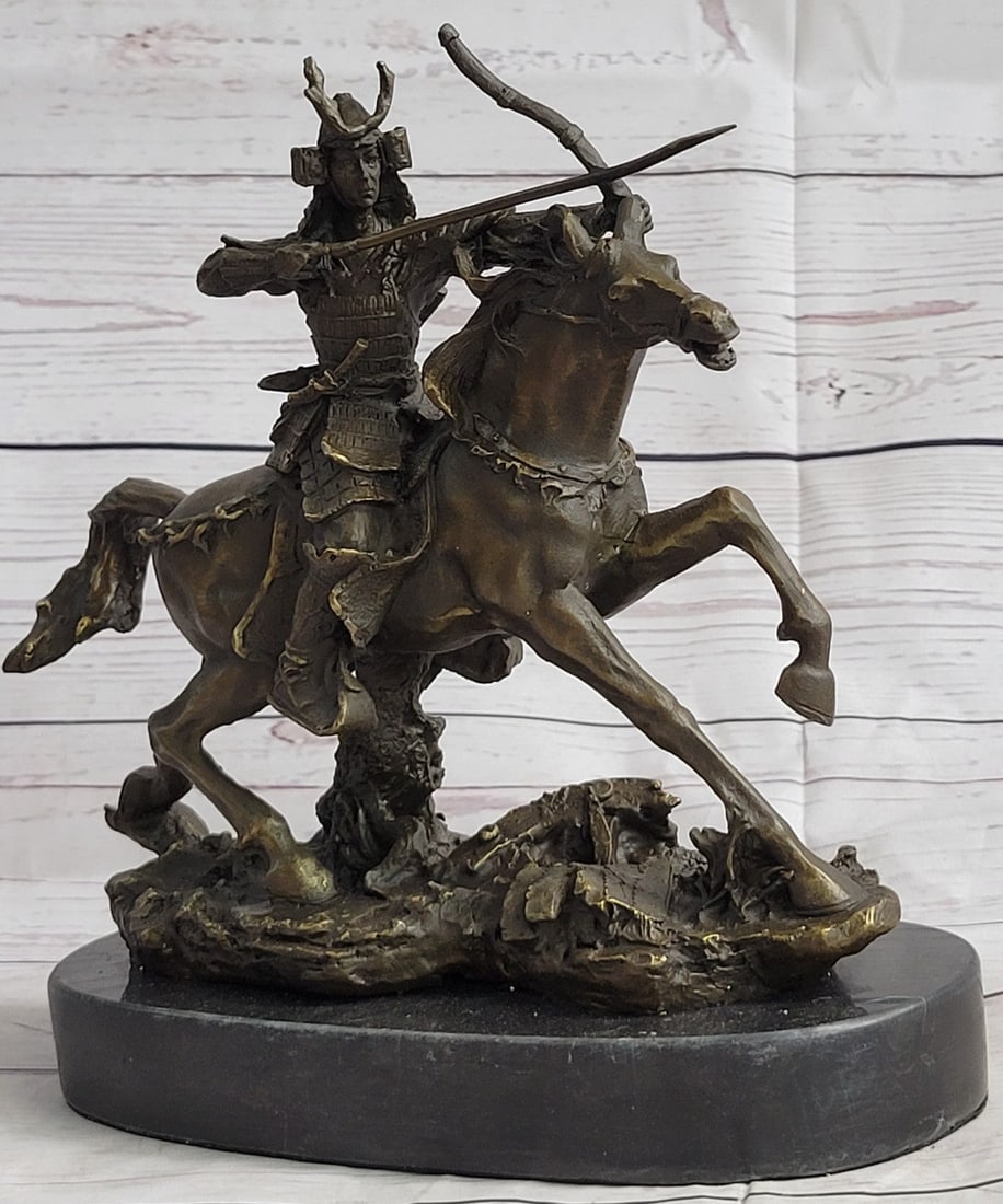 Samurai Warrior on Horse Bronze Sculpture: A fierce ancient Samurai warrior races to the front line of battle on his loyal and speedy steed. His horse rears back as he raises his bow with determination, ready for anything. He is dressed in pro