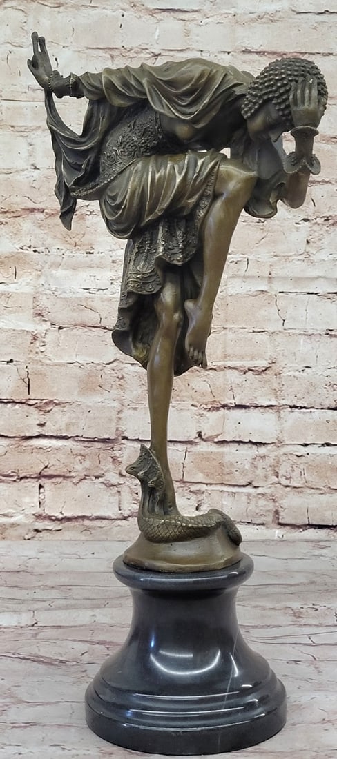 Dancer with Striking Pose Bronze Sculpture: The exemplary depictions of dancers, influenced by Russian and French culture. This woman is wearing a creatively designed costume equipped with a skirt and and a studded cap. She poses while in a fan