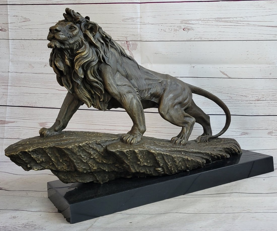 Wild African Lion on Prowl Bronze Sculpture: The regal lion in all his majesty, walks up a cliff in the golden glow of a setting sun, overseeing the expansiveness of his kingdom. The plains winds tangle the fur of his mane as he stares out at