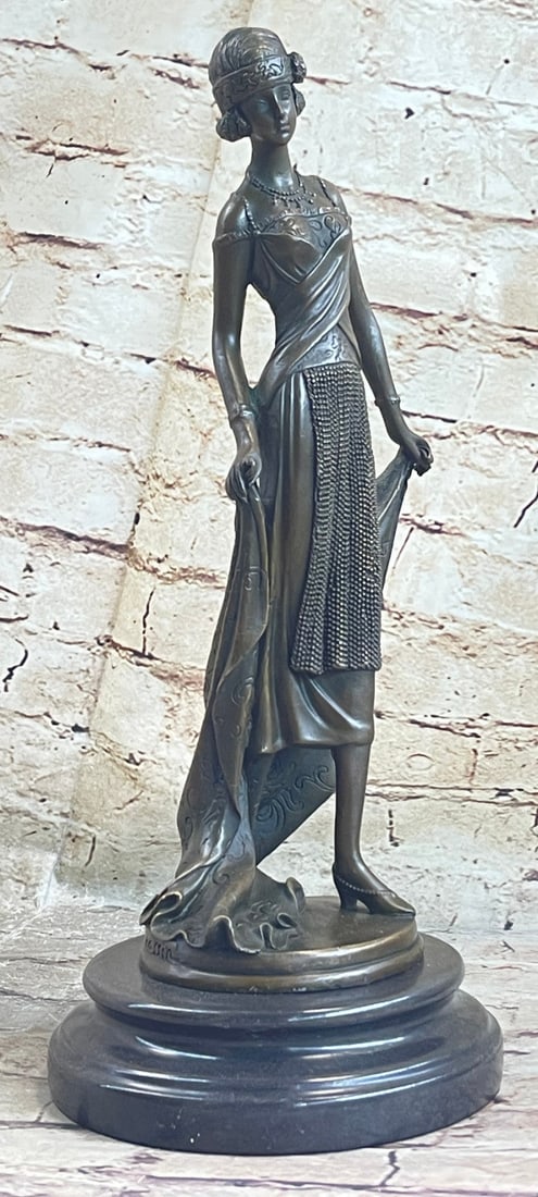 Lady is Poised and Elegant Dressed Bronze Sculpture: The High Society Lady Is Poised And Elegant Dressed Head-To-Toe In Elaborate Garments. The Top of Her Dress in Embroidered With A Mesh Like Top And Decorated With A Large Flower. A Beautiful Cape Exte