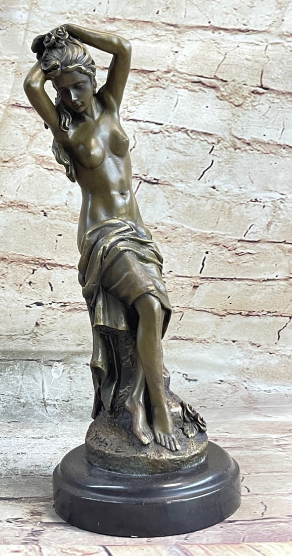 Nude Female Sitting Bronze Sculpture: A beautiful nude woman stands confident with her air surrounding an imaginary water jug. Like a cape, the cloth of her garments ripples on her back. Her hair is swept up in a loose bun and is topped