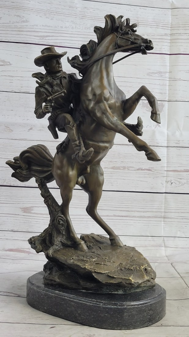 Western Cowboy with Bucking Horse Bronze Sculpture: It is the Wild Wild West! This gunslinger, comfortable on his rearing horse, looks over the horse neck to watch ahead for his enemy. He is ready to fire his weapon if need be as he travels hurriedly t
