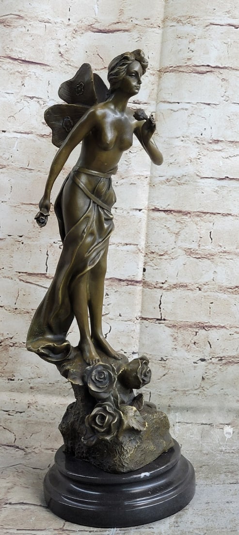 Fairy Bronze Sculpture: A Winged Lady with A Flower in Each Hand. This Is a Genuine Hot Cast Bronze Finished on A Marble Base. This Sculpture Was Cast Using The Lost Wax Method and It Is Mounted On A Marble Base.