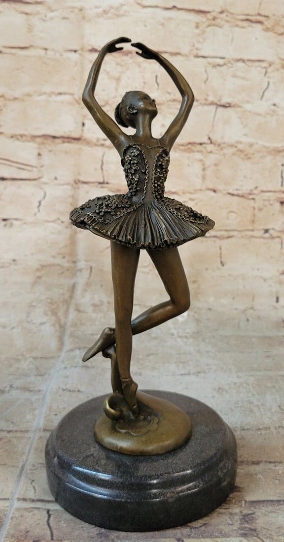 Ballerina Dancer Bronze Sculpture: A prima ballerina puts on a show. She elevates her long leg far behind her. Her chest pushes out and her head tips up to the sky, basking in the glory of being center stage. Her spine curves, touching