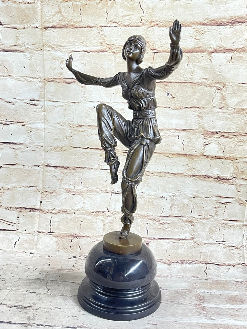 Dancer Figurine Bronze Sculpture: This dancer lifts her leg as she holds out her hands and dances to the music that plays through the night. She wears slipper-like shoes her pants are tied at the ankle bunching them up She wears an