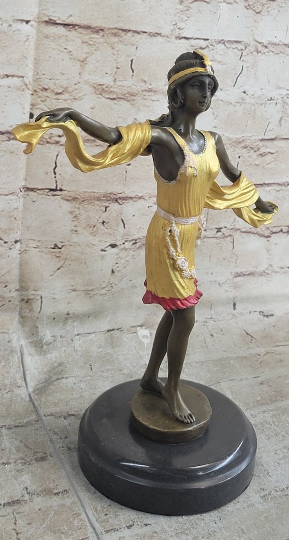 Dancer Bronze Statue: It is a bright yellow patina but the hemline is pinkish-red. A matching yellow sash loops around her arms. This sculpture was cast using the Lost Wax Method and mounted on a marble base. Dimensions: H