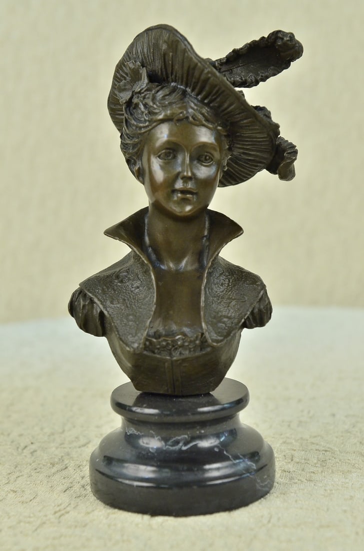 Classy Lady Bust Bronze Sculpture: This is an amazing bust of a young woman from the 1900s. She has a gorgeous hat while her hair is up in a unique style. She is wearing a corset extremely tight and a high collar blazer that suits her