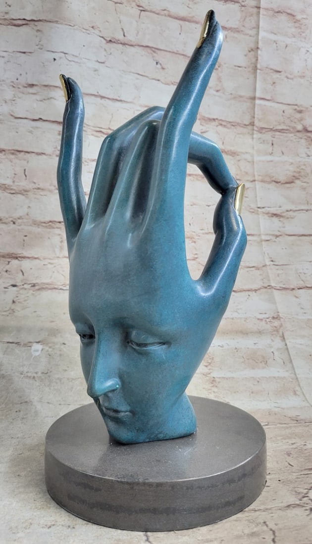Human Face Hand Bronze Sculpture: This extravagant and abstract piece was designed and made of bronze. It features a realistic-looking human hand and forearm with the wrist slightly bent and fingers spread apart.?The hand is offset