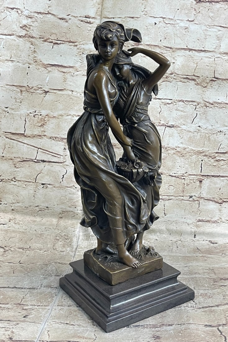 Two young Girl in Flower Dress Bronze Sculpture: A bronze figural group of Consolationdepicting two young girls in flowing dresses, one holding the arm of the other, the other holding a ribbon-tied basket of flowers. This bronze sculpture was cast