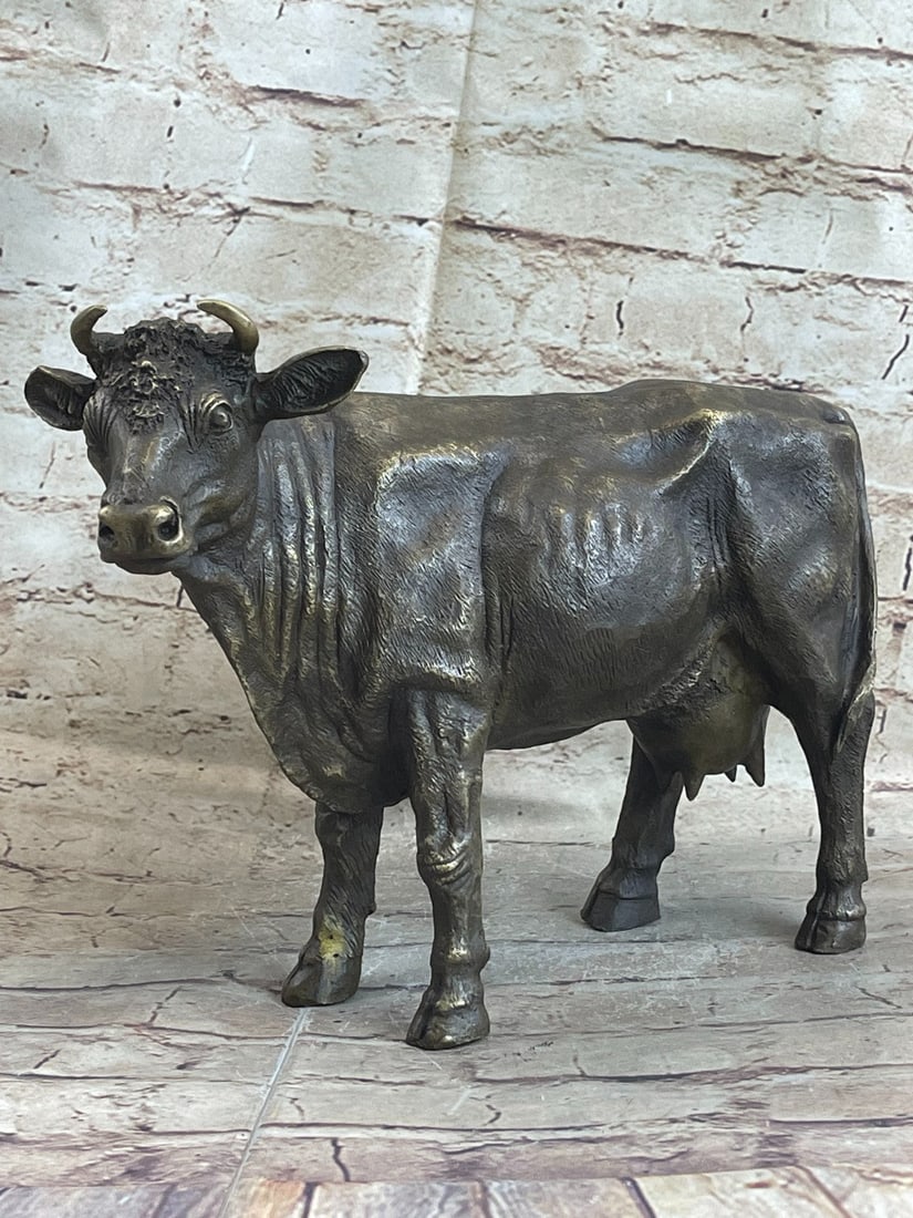 Female Cow Bull with Horn Bronze Sculpture: The female cattle trots along with the grassy fields she calls home. Her horns protrude out from the top of her head. The muscles in her body show through her skin. The craftsmanship highlights the