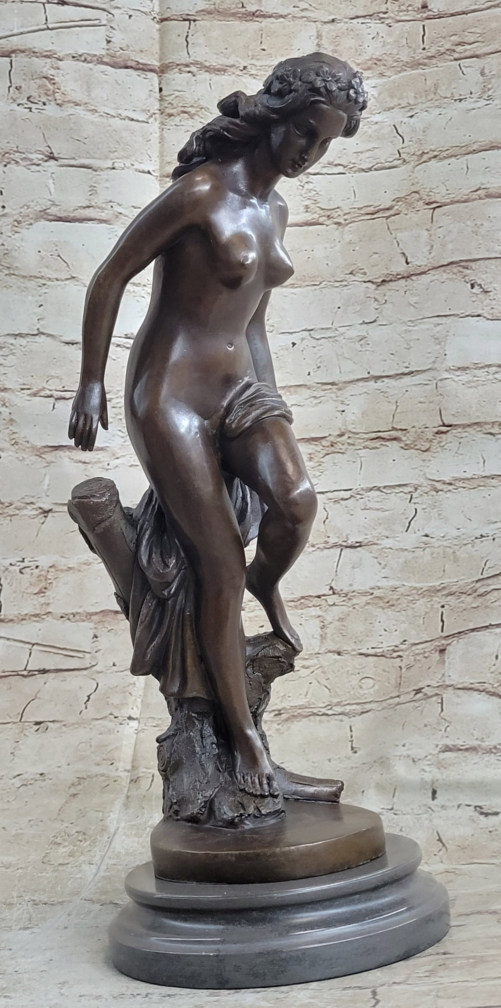 Maiden Bronze Sculpture: The nude beauty, molded with a Neoclassical perception, is seen stepping down a wind-whipped cliff. She moves cautiously perceiving her next step with all the grace of her delicate form. She is