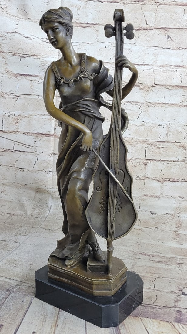 Lady Playing Cello Bronze Sculpture: A young woman plays a soothing song on her cello. She leans in forward to get a better grip on her instrument. She leaves her eyes open to catch the audience's attention while she plays, she listens t