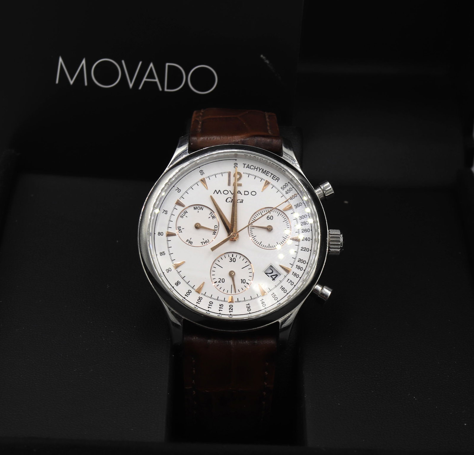 Movado Circa white dial watch with brown leather strap: Movado Circa white dial stainless steel watch with brown leather strap. Comes with Inner and Outer box and booklet. Total weight of watch 67.20 grams.