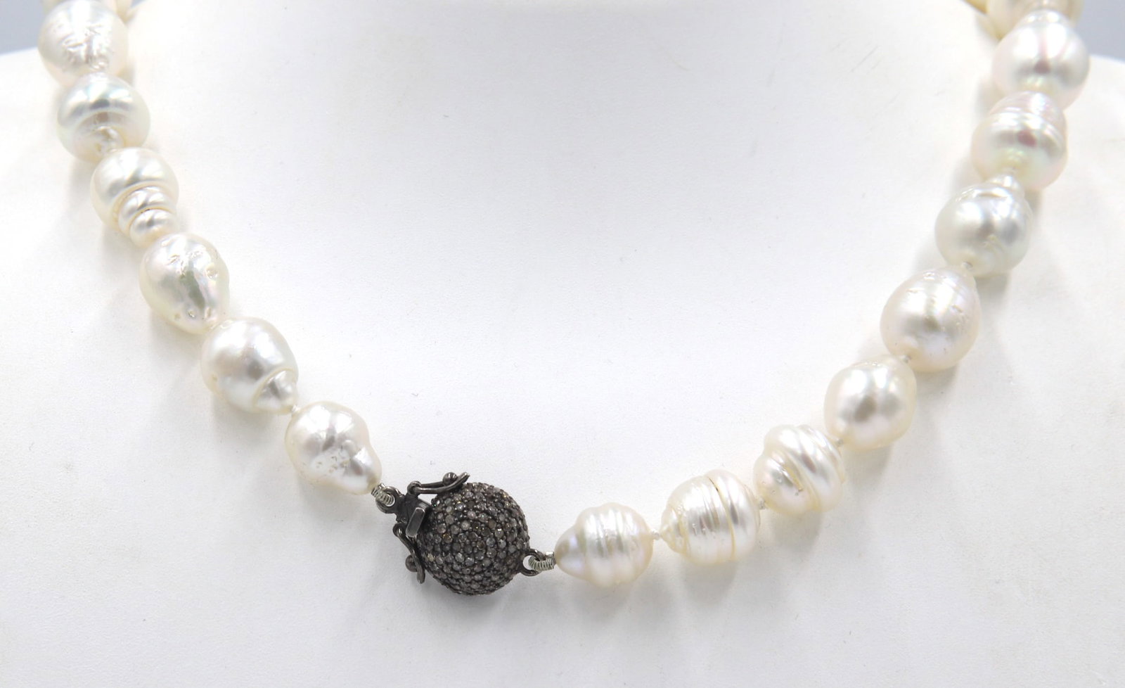 Barqoue pearl necklace: This Dazzling Pearl Strand Necklace features White Barqoue Pearls highlighted with a 925 Sterling Silver approx. 0.92CTW Pave Diamond Clasp. ?This necklace weighs approx. 73.89 Grams.