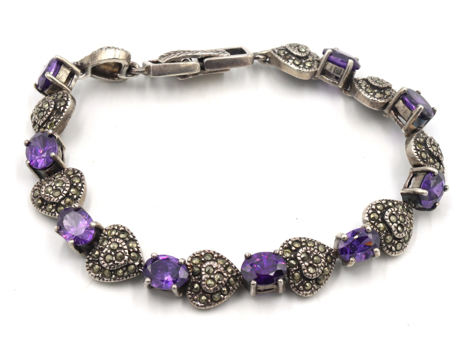 925 Sterling silver marcasite and amethyst link bracelet: 925 Sterling silver marcasite and amethyst link 7.25-inch bracelet. The total weight of the bracelet is 30.14 grams.