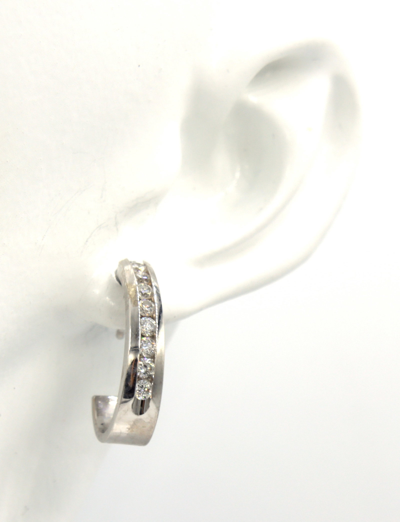 14kt White gold channel set J hoop earrings: 14kt White gold approximate 0.35ctw channel set J hoop earrings. The total weight of the earrings is 3.78 grams.