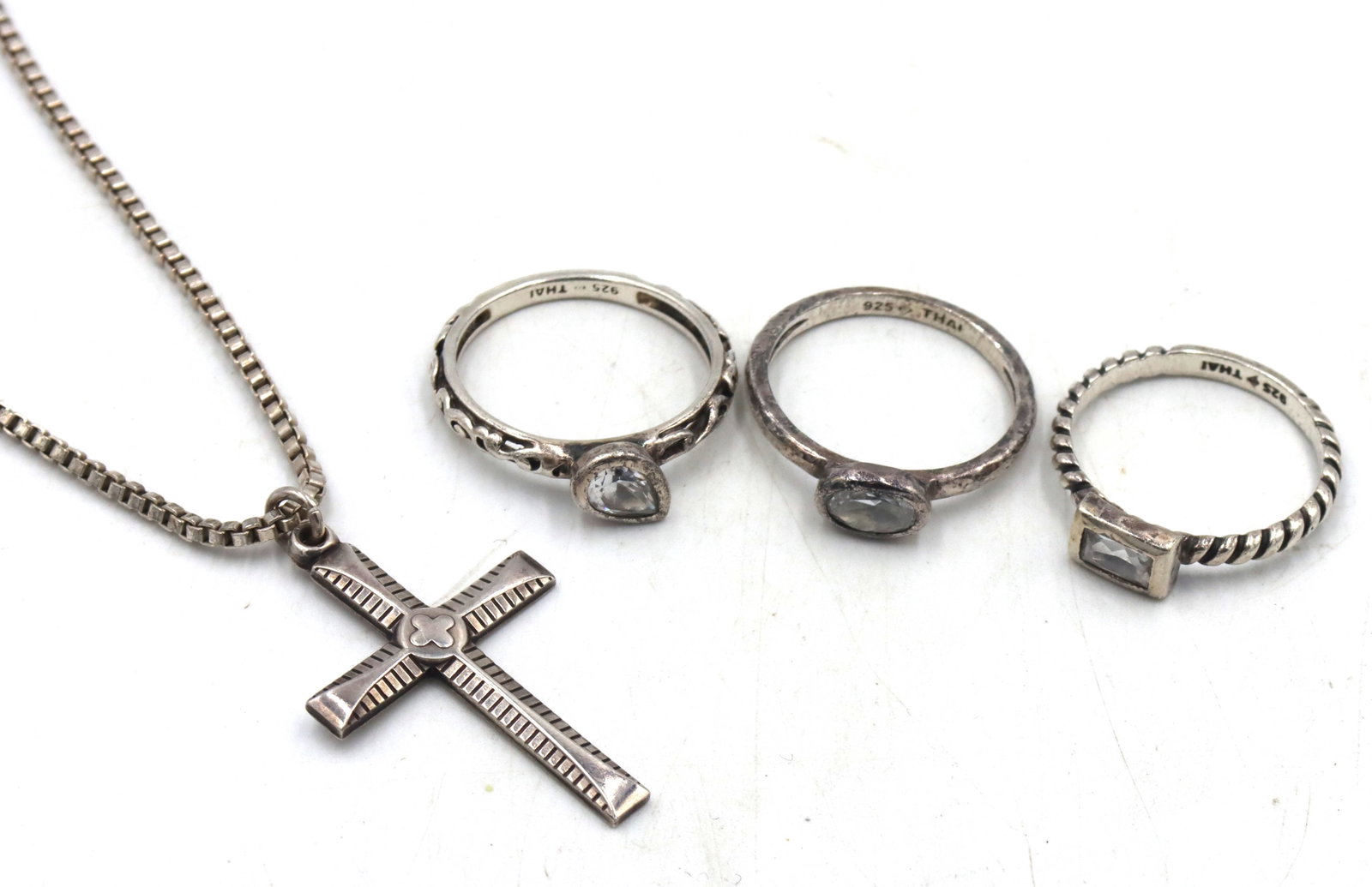 Group lot of vintage 925 sterling silver mixed jewelry: Group lot of vintage 925 sterling silver mixed jewelry. 3 Rings, Cross pendant on 20-inch Italian box chain necklace. The total weight of the lot is 14.20 grams.