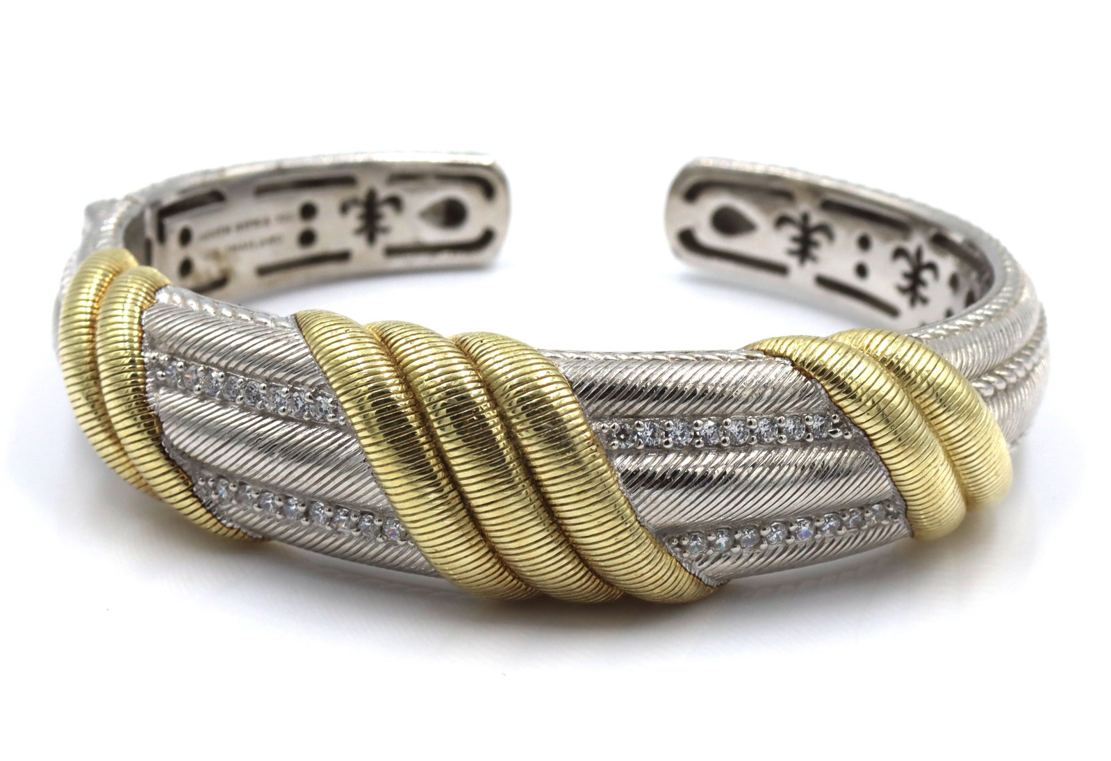 Judith Ripka cuff bangle in 925 sterling silver: Judith Ripka signed gold clad hinged cuff bangle in 925 sterling silver. The total weight of the bangle is 59.1 grams.
