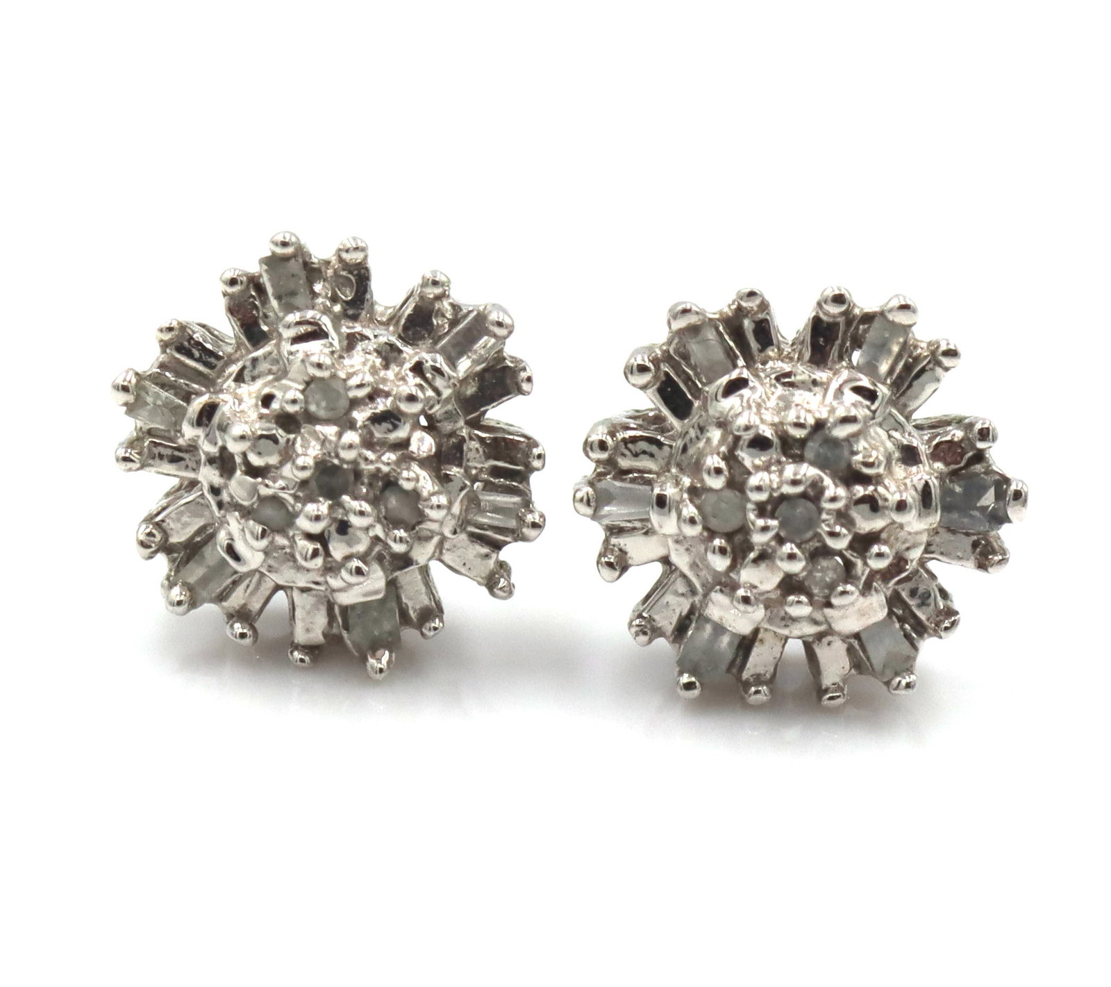 10kt White gold diamond flower style stud earrings: 10kt White gold diamond flower style stud earrings. No backs. The total weight of the earrings is 1.6 grams.