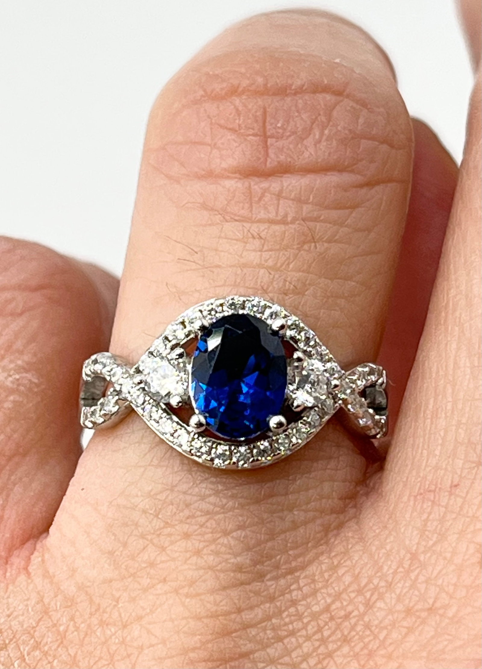 925 Sterling Silver Oval Blue Center Stone With Crystal Pave Details Ring: 925 Sterling Silver oval blue center stone with crystal halo and twisted bypass shank ring. 3.3 grams, size 7