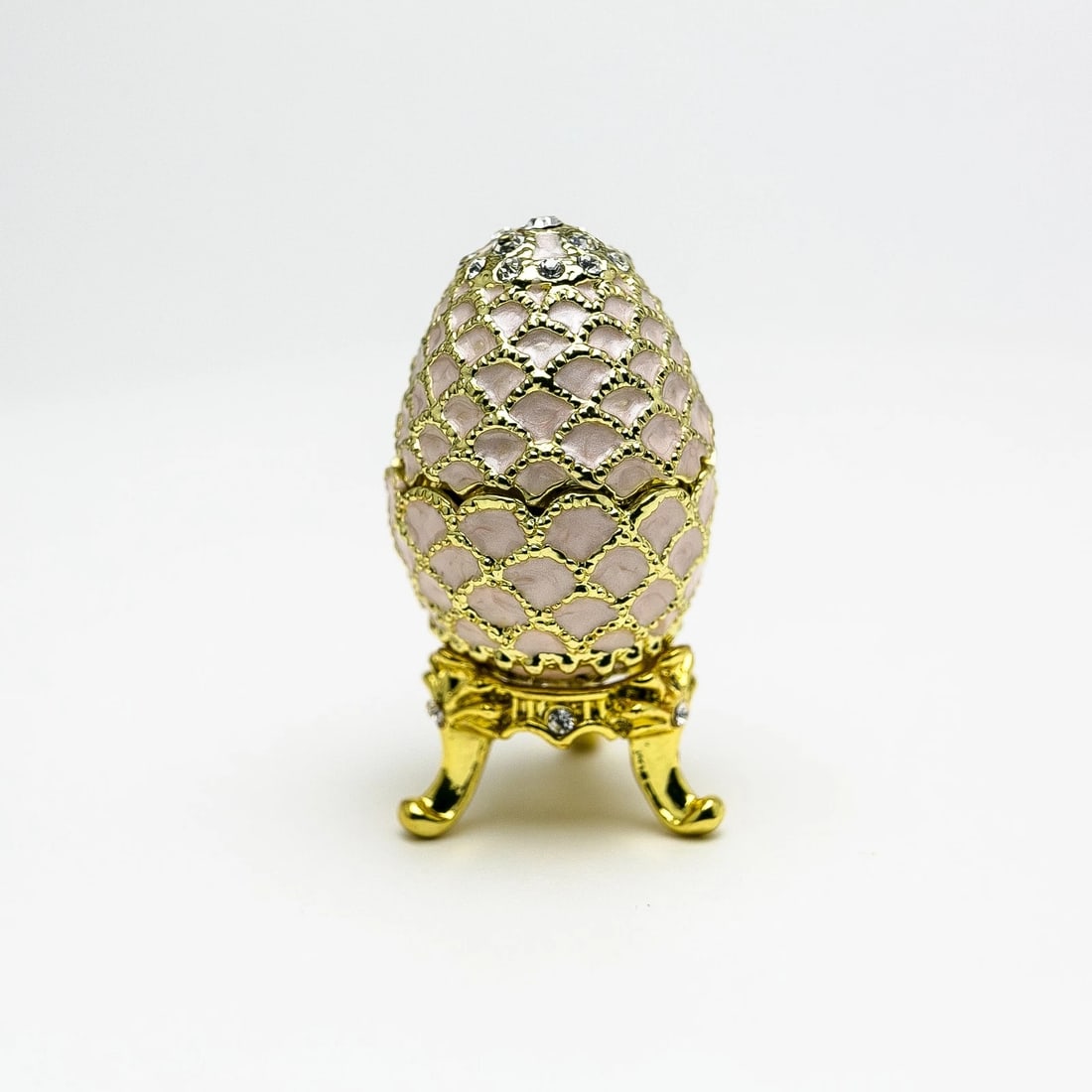 Hand-Painted Golden Pink Enamel Egg Trinket Box with Crystal Accents: This elegant hand-painted enamel trinket box is designed in a classic decorative egg shape with a refined golden pink finish. Carefully crafted by skilled artisans, each piece features individually pl
