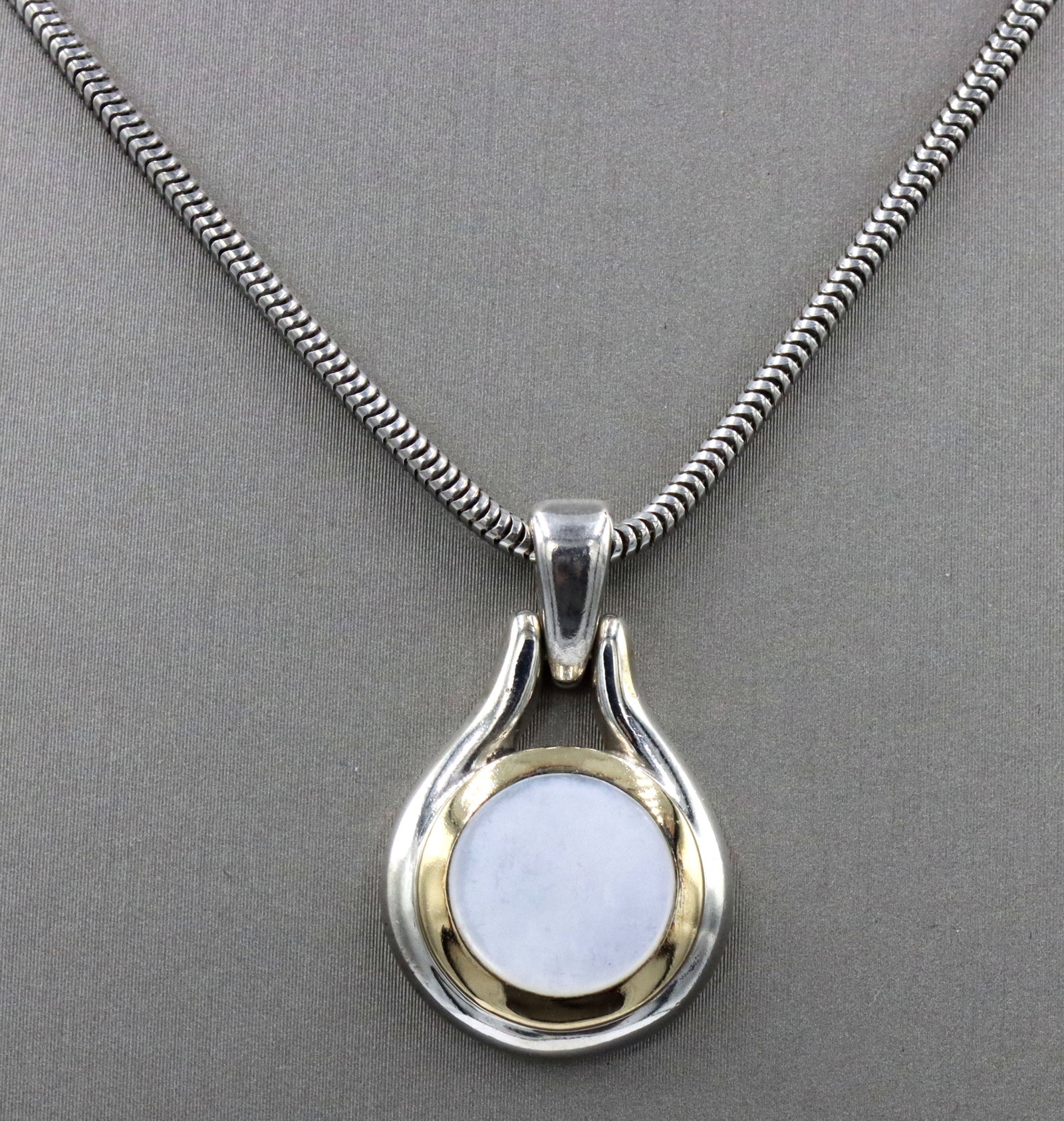 Tiffany & Co 2 tone mother of pearl pendant on snake chain: Tiffany & Co 2 tone mother of pearl pendant on 16-inch snake chain necklace in 925 sterling silver. The total weight of the necklace is 13.32 grams.
