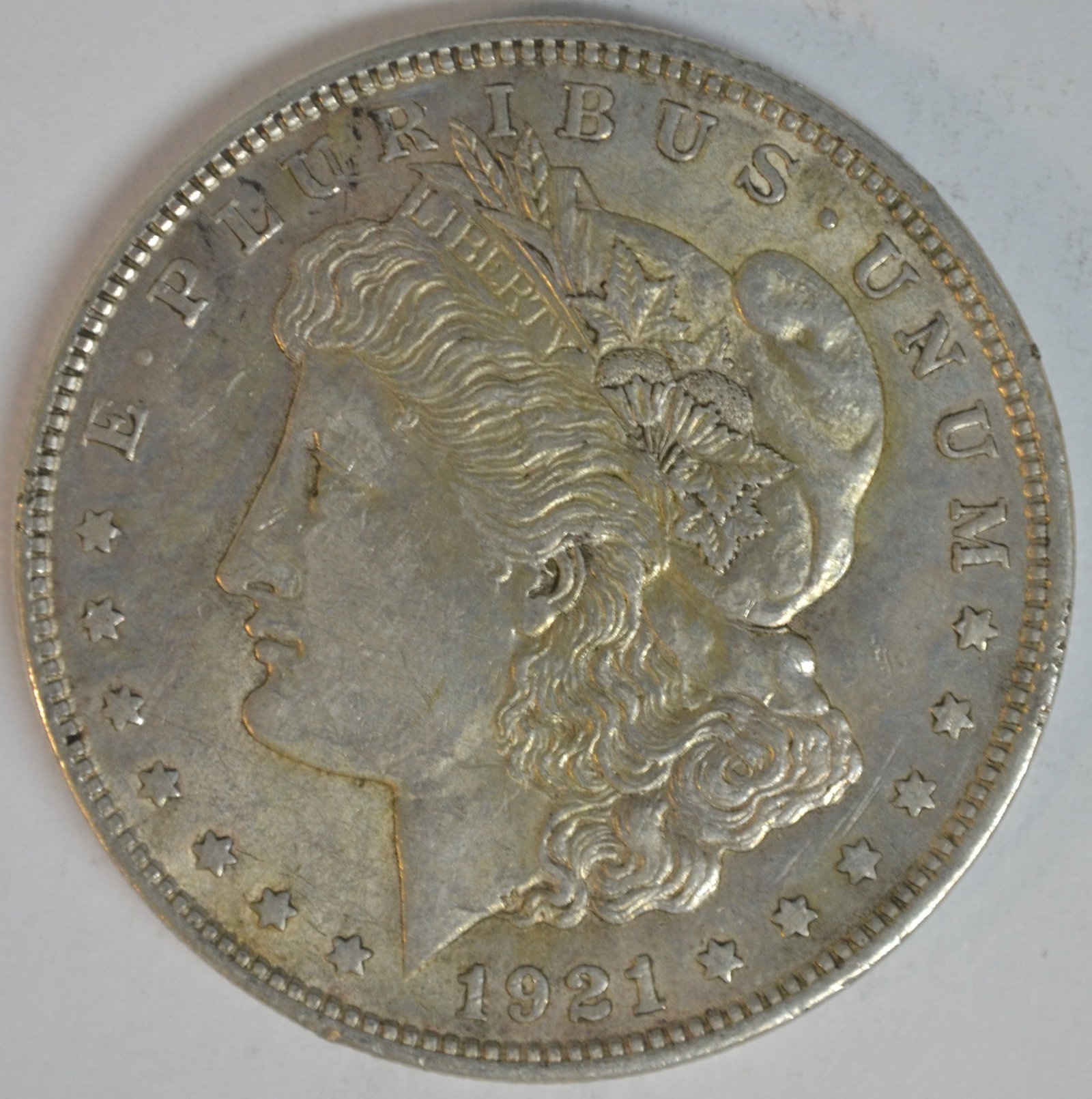1921 Morgan Silver Dollar Philadelphia Mint About Uncirculated (AU Details) Classic American Silver: 1921 Morgan Silver Dollar, the final year of issue for the beloved Morgan Dollar series. Struck in 90% silver at the Philadelphia Mint (no mint mark), this coin features George T. Morgan's iconic Libe