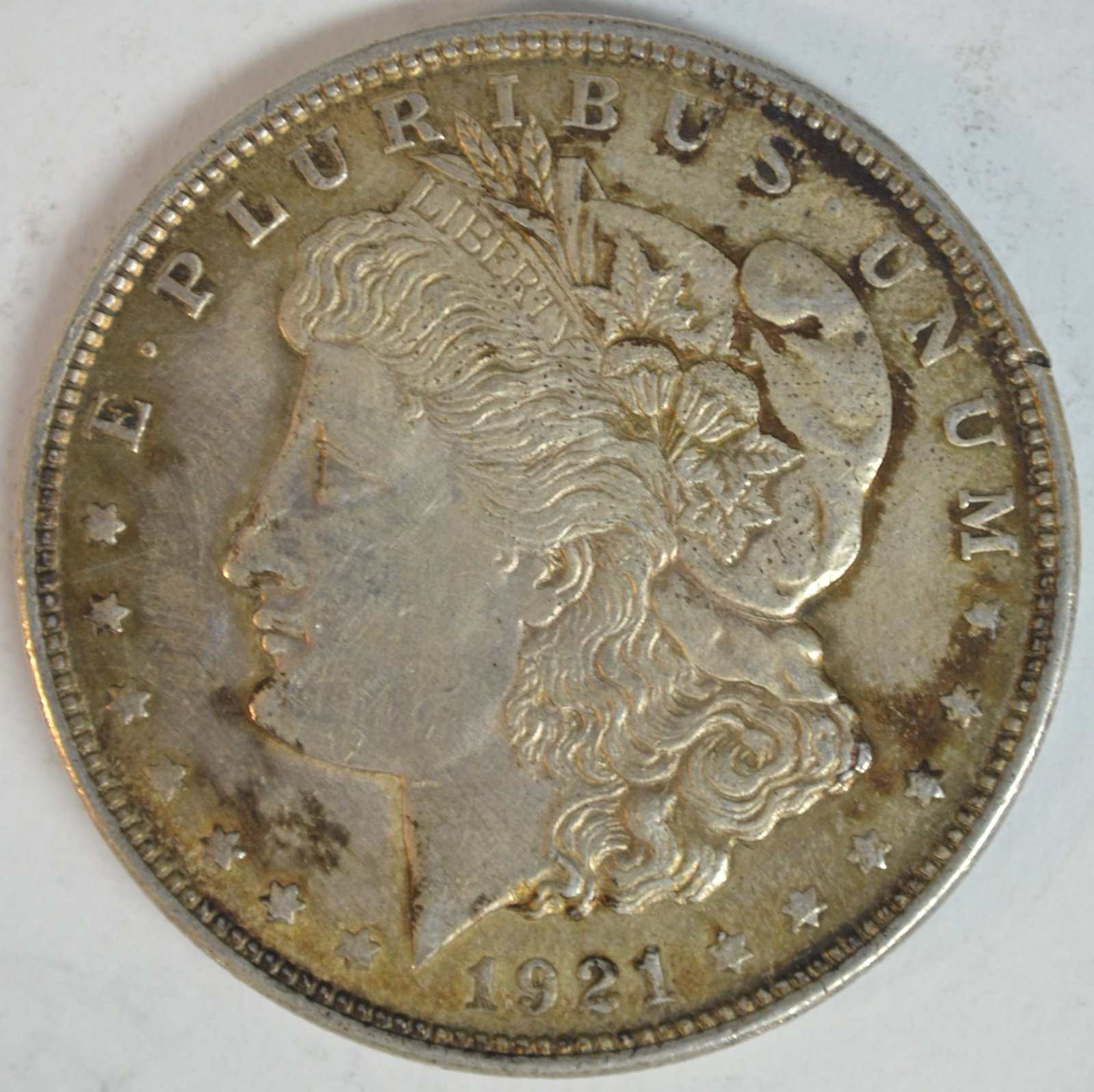 1921 Morgan Silver Dollar Brilliant Uncirculated Details, Attractive Peripheral Toning: 1921 Morgan Silver Dollar, the final year of issue for the beloved Morgan Dollar series. This coin displays strong remaining luster with sharp hair detail above Liberty's ear and excellent feather det