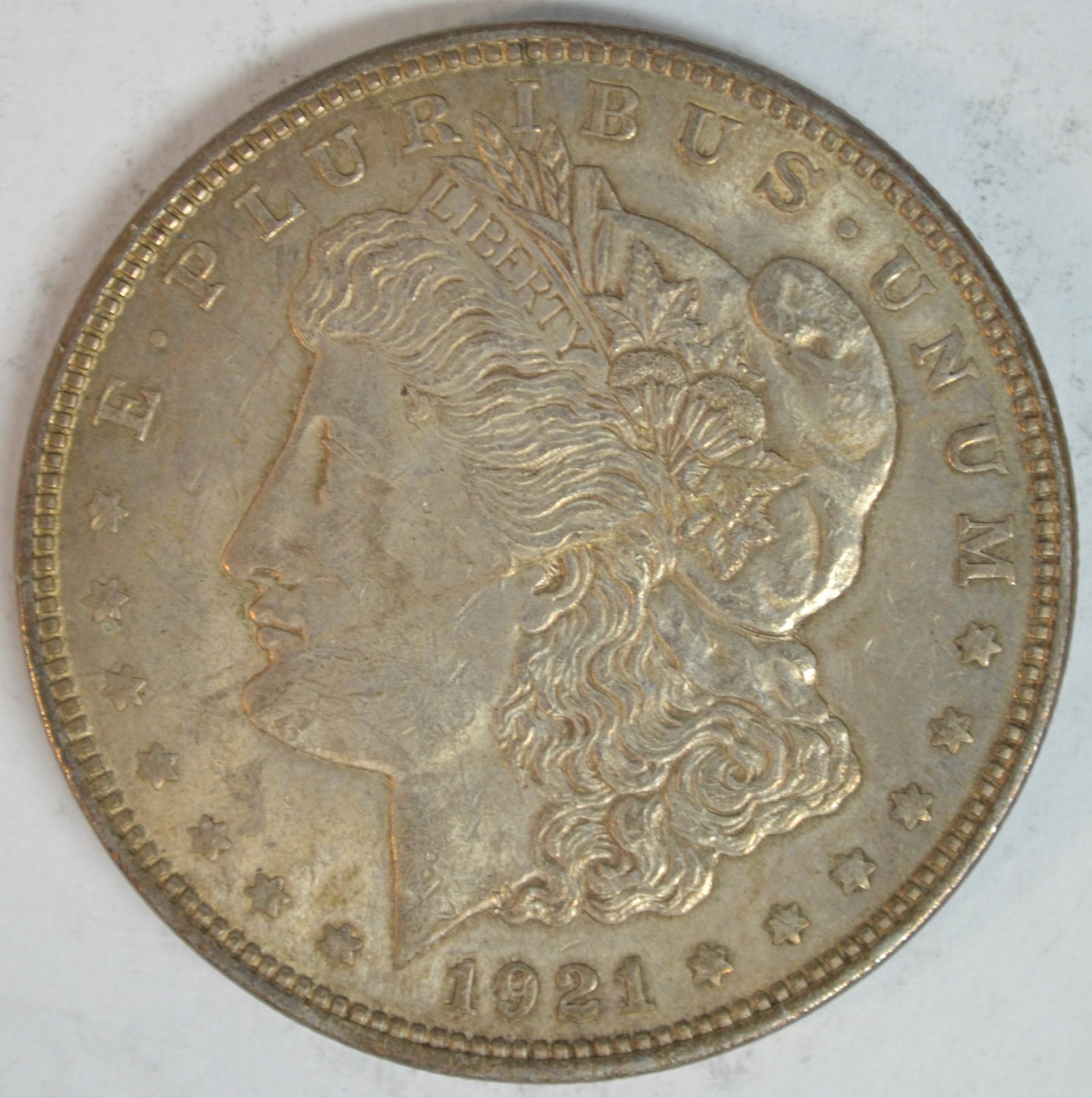 1921 Morgan Silver Dollar Philadelphia Mint About Uncirculated (AU) Details: 1921 Morgan Silver Dollar, the final year of the beloved Morgan Dollar series. Struck in 90% silver at the Philadelphia Mint (no mint mark), this classic American silver dollar features George T. Morg