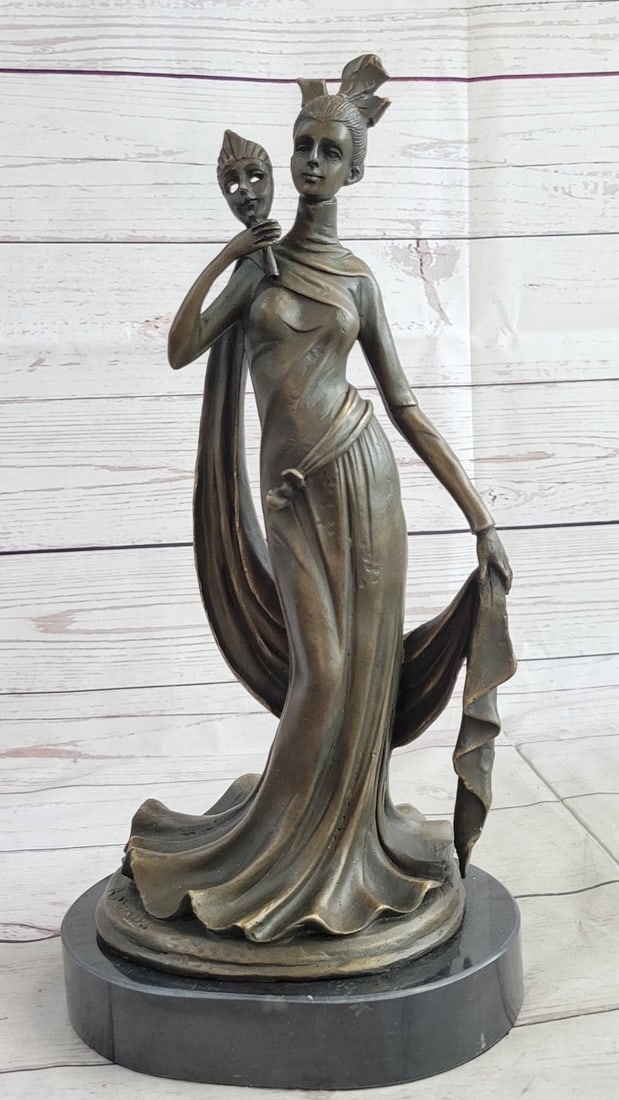 Girl Holding a Mask Bronze Sculpture: This Sculpture of a 1920s woman is a beautiful piece for an exquisite living room or a young ladys bedroom. As she stands elegantly for her photo shoot, who can forget to mention her unforgettable