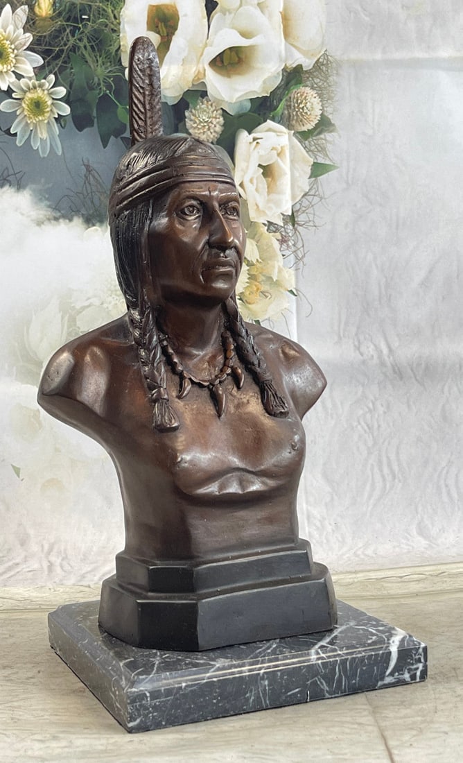 Chief Bust Bronze Sculpture: This is an exquisite Bronze bust of a Native American warrior chief. He stares at the beholder, wild and bold, with an air of spiritual resilience. His hair is adorned with braids that are wrapped