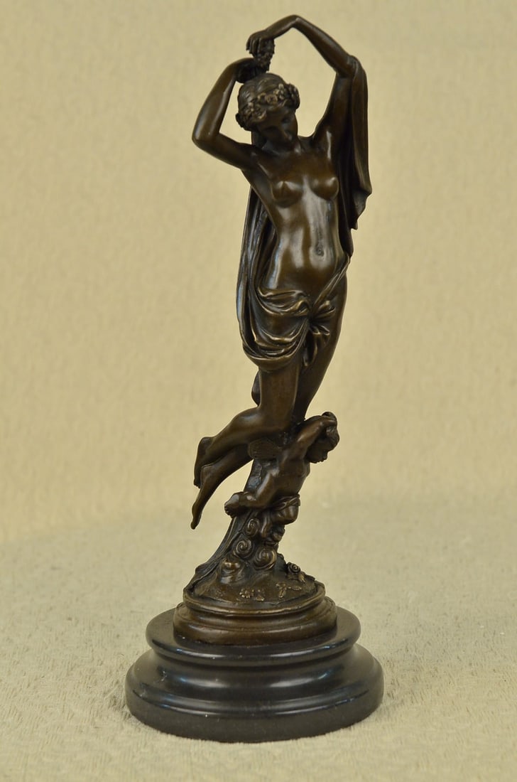 Nude Lady with Angel Bronze Statue: The beautiful maiden seems to glide into the air on the back of a winged cherub. This sculpture is laden with the Hellenistic approach of art with it is mythology and natural grace. She kneels on the