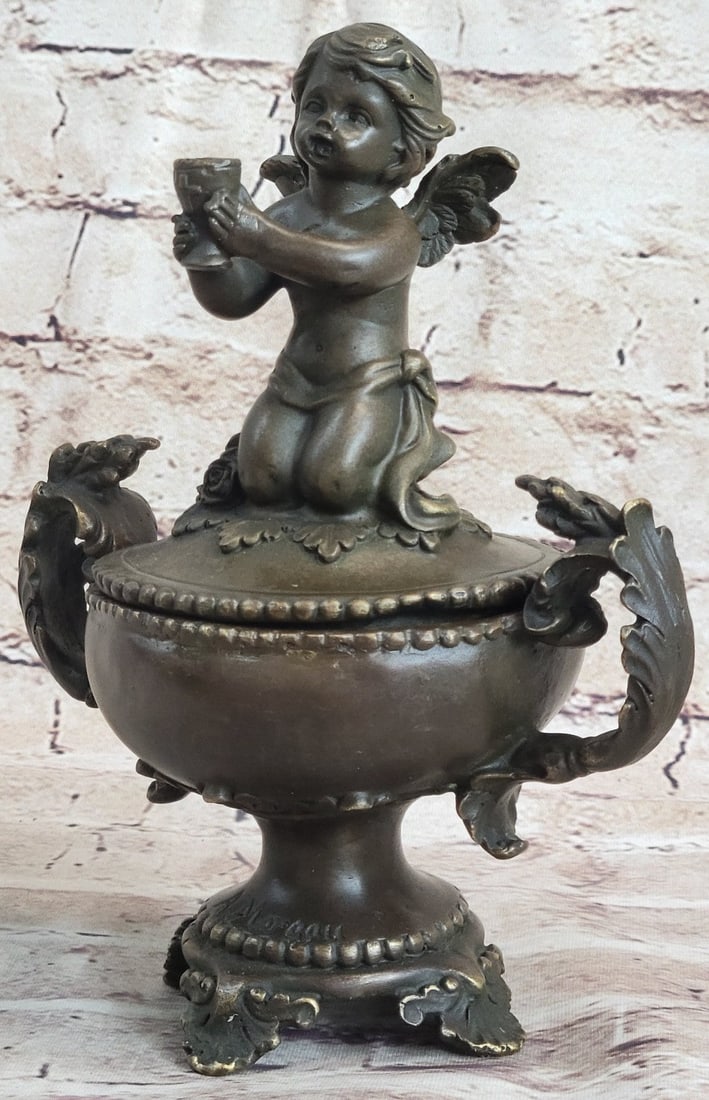 Baby Angel Jewelry Box Bronze Sculpture: This jewelry box features young putti resting peacefully holding a cup. His facial expression is one of complete serenity. He sits atop a flower-shaped base intricately adorned with tiny flowers and