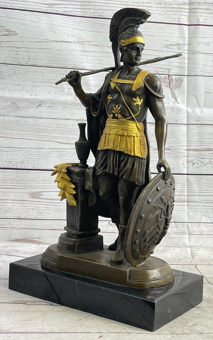 Greek Warrior Roman Soldier Bronze Sculpture: The Roman legion soldier stands nude, except for some regalia, looking to the horizon of a scarred battlefield. On the top of his head, he wears a galea, which is a soldier helmet. A baldric straps